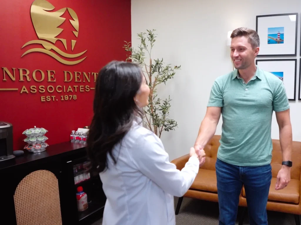Dr. Khong shaking hands with smiling patient coming in for wisdom teeth removal in Conroe, TX