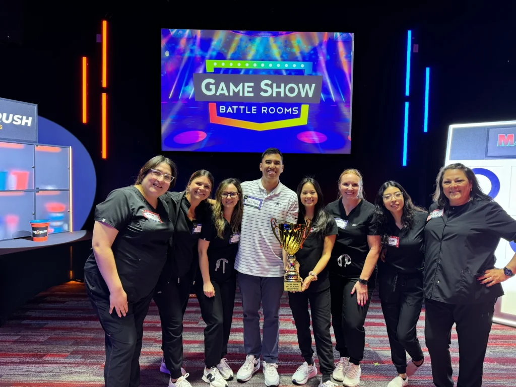 Conroe Dental team holding the Game Show Battle Rooms championship trophy